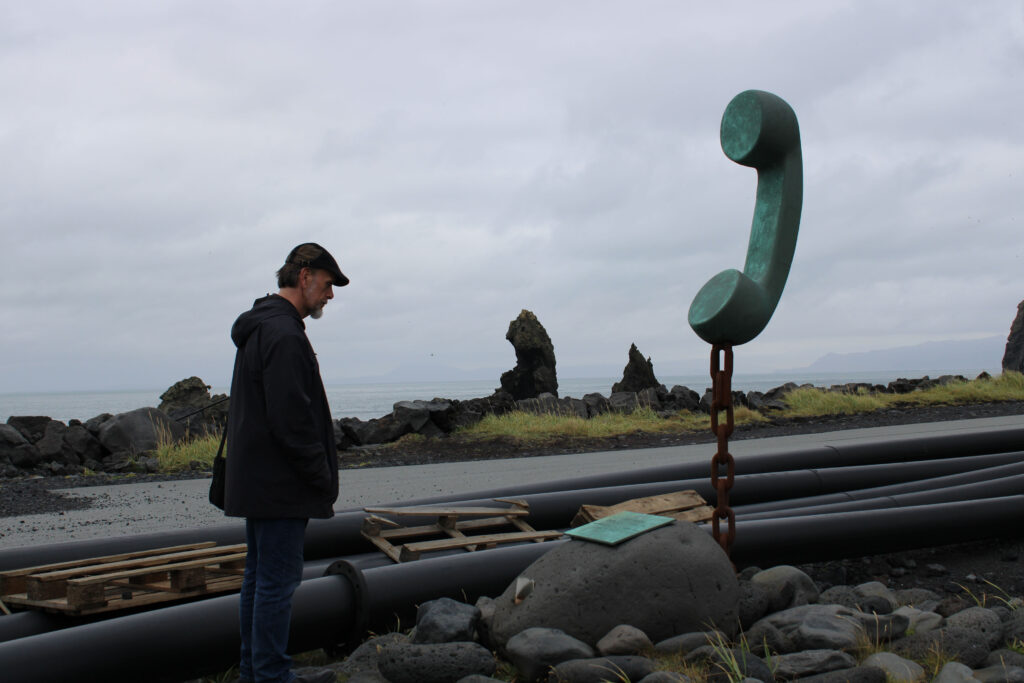 Jürgen reading the Icelandic signage of this telephone memorial in the harbor